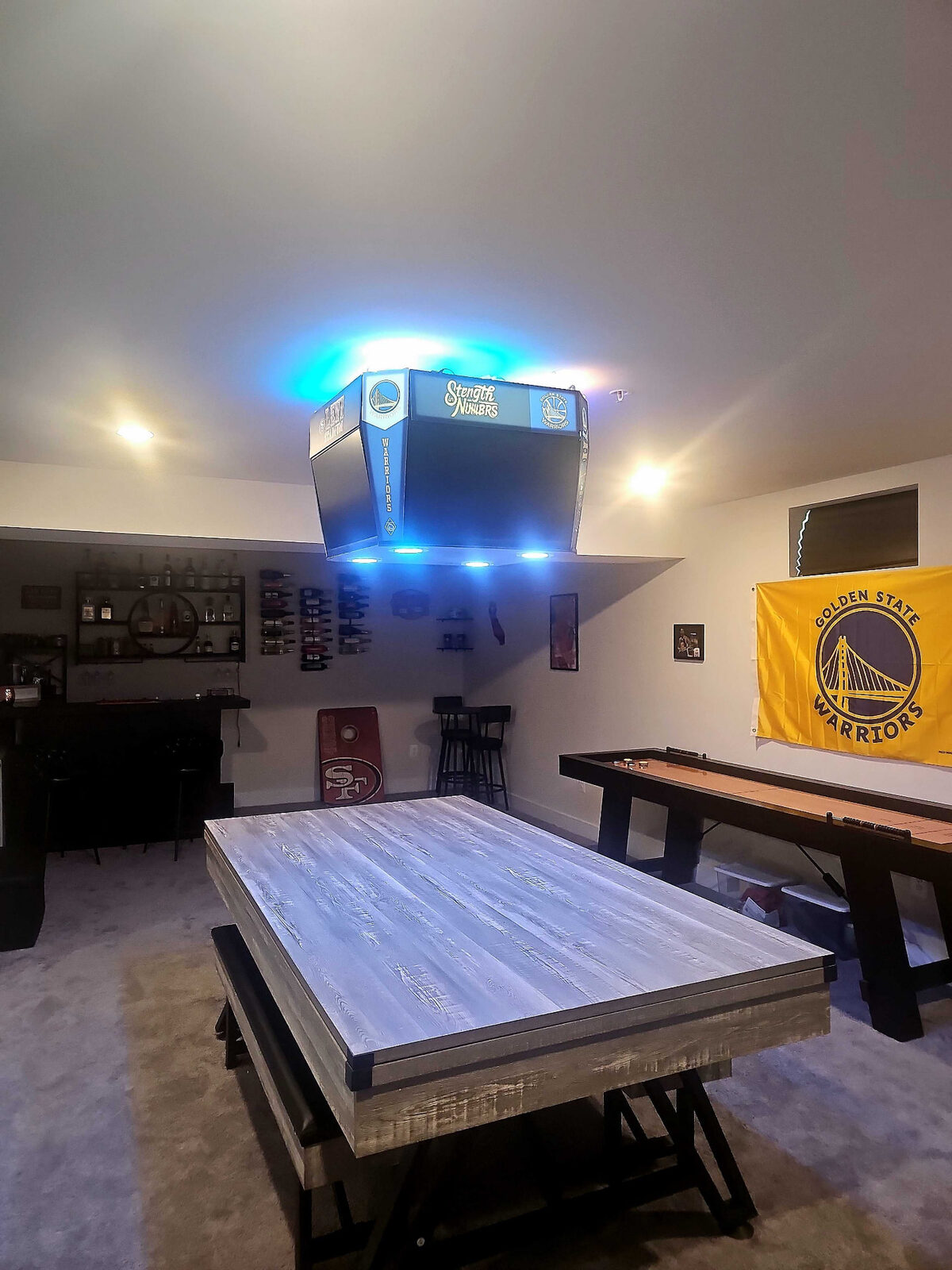 TV mounted on a pillar in a finished game room bar