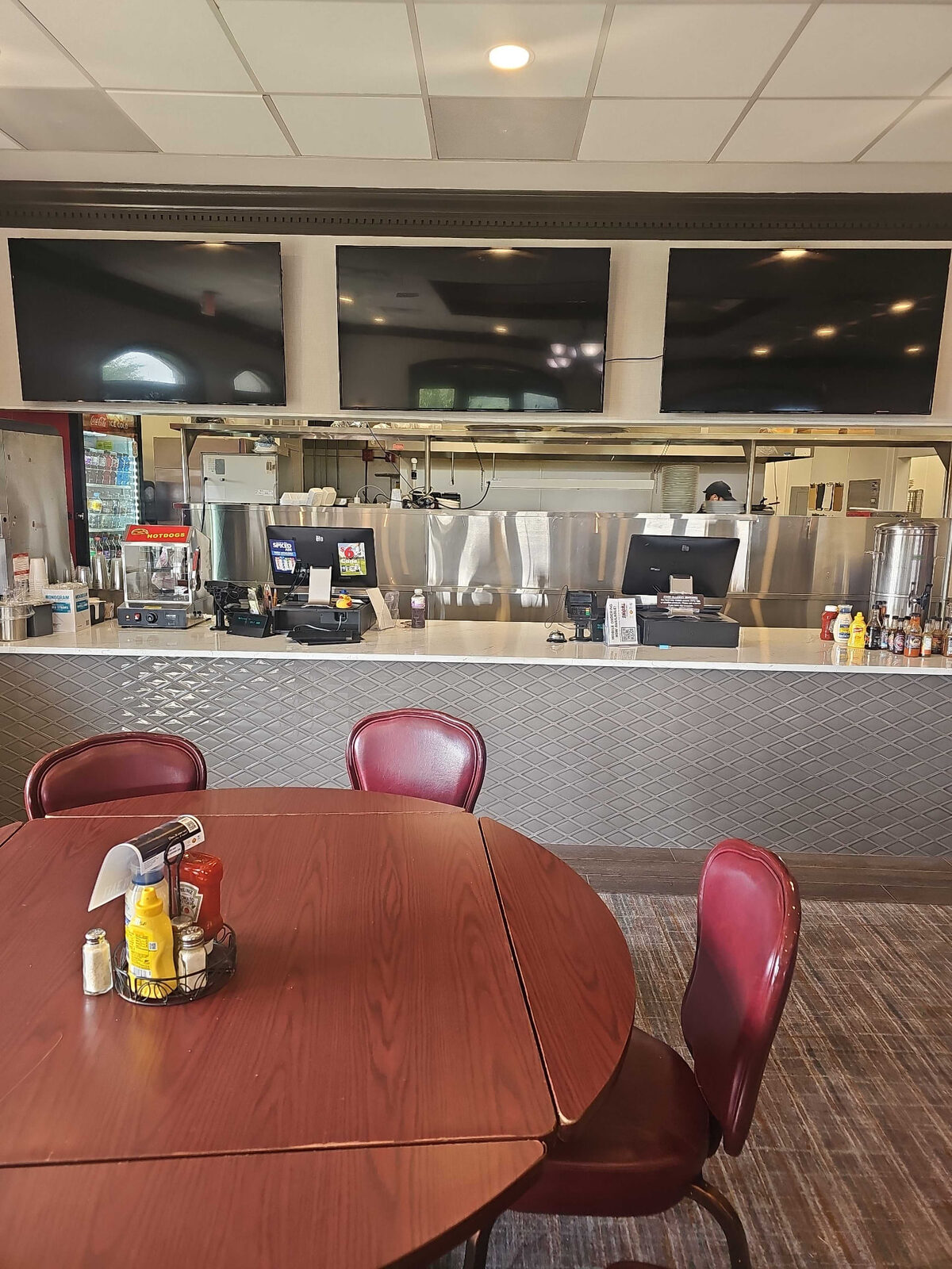 Three TVs mounted above a restaurant counter