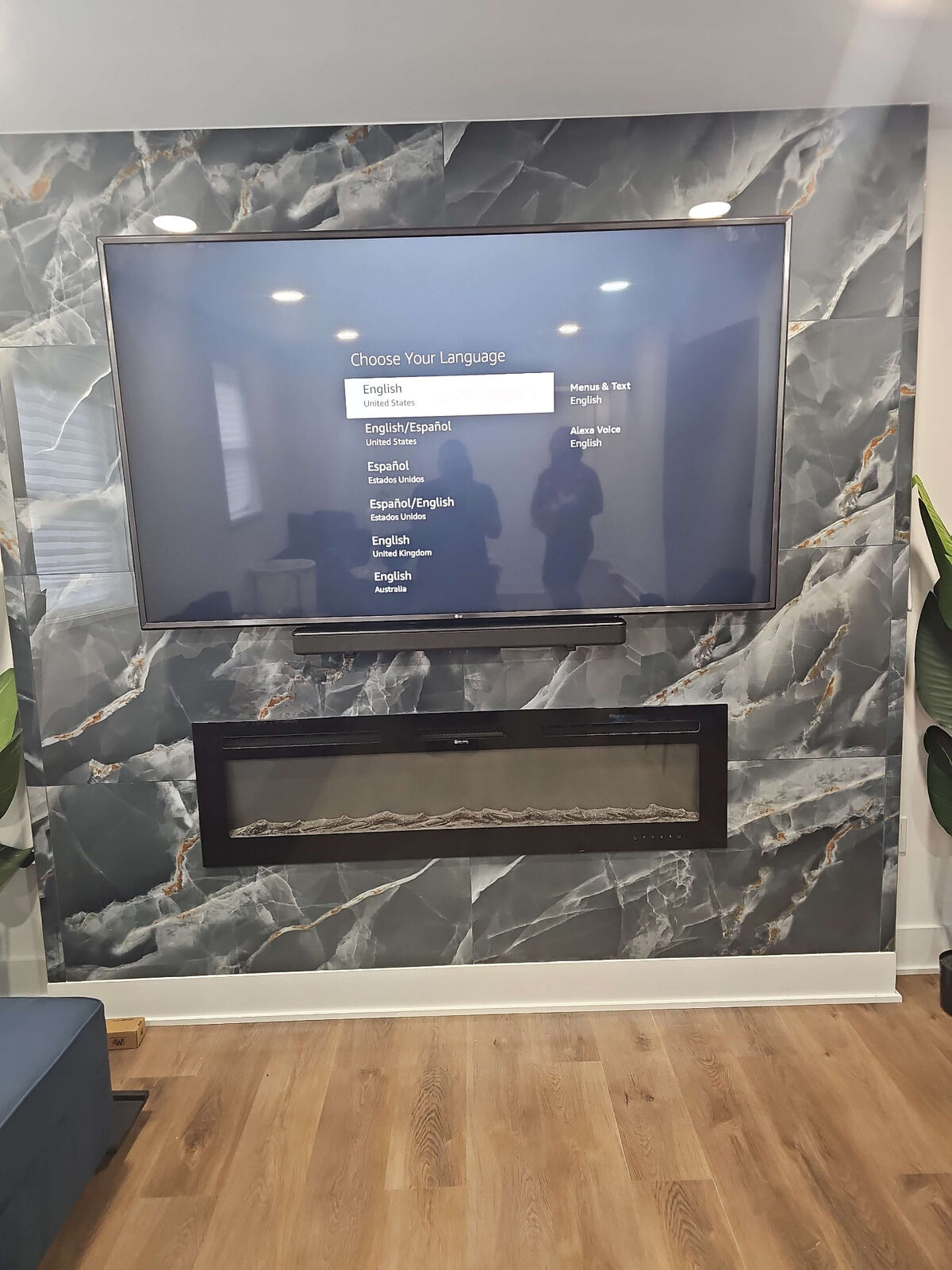 LG TV and soundbar mounted over a marble fireplace