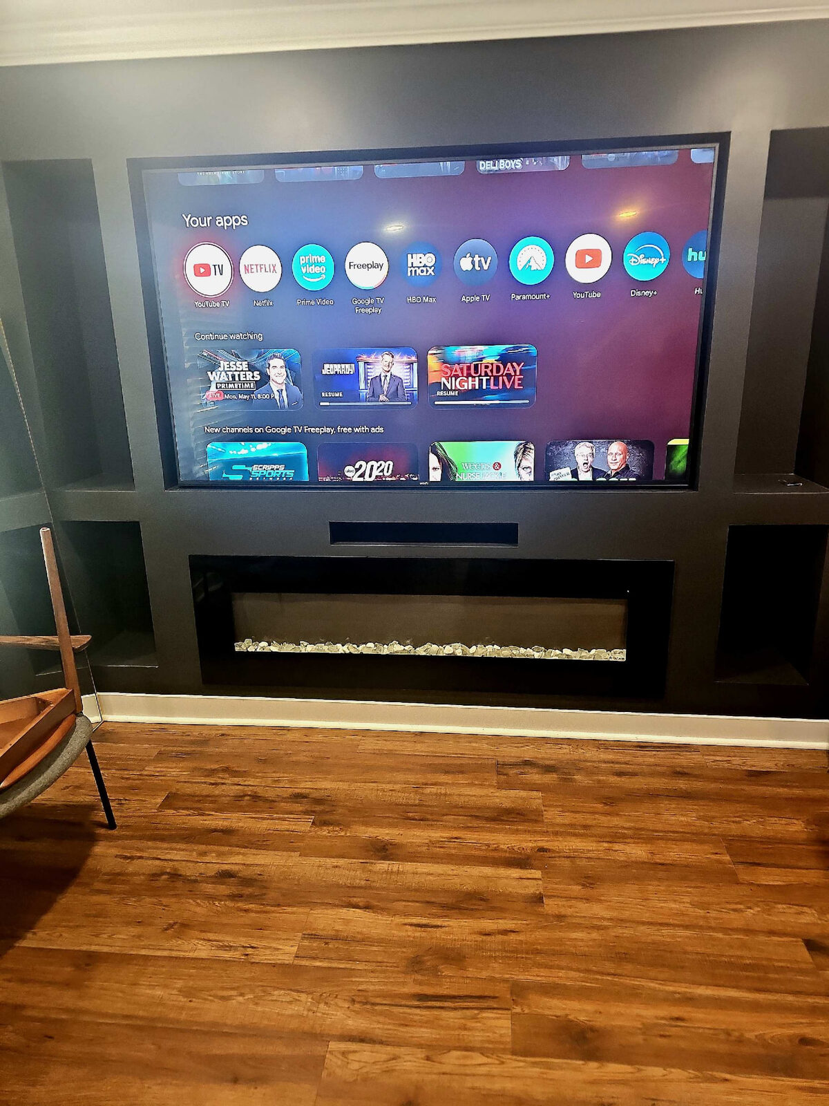 Large TV with soundbar built into a custom fireplace wall unit